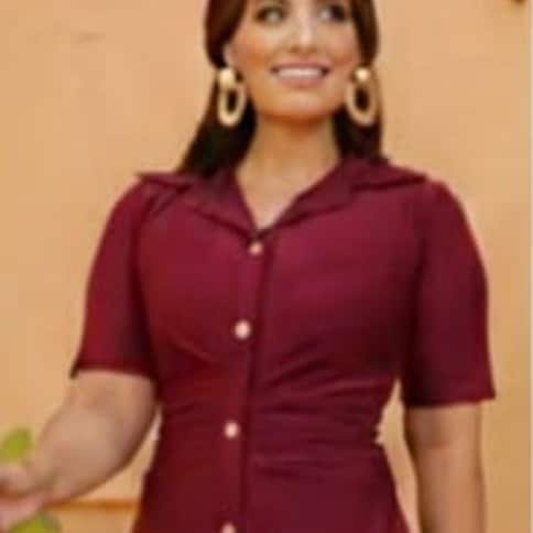 Modelo sorrindo com vestido chemise vermelho-vinho, gola de camisa e botões dourados